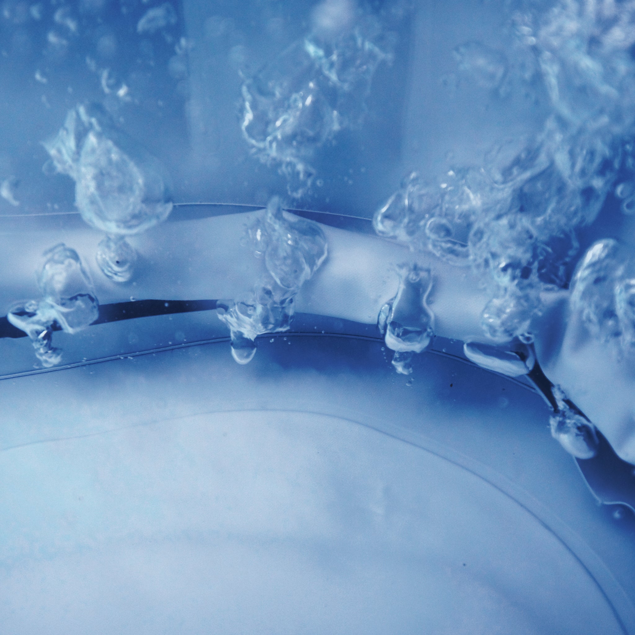 Underwater photo showing a close up of bubbles coming out of the base of a spa with a blue interior lining, illustrating the variable speed massage and air therapy features of the MSpa hot tub jacuzzi range.