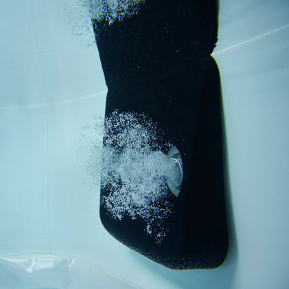 Underwater close up image of spa hydro jet blowing out a jet of bubbles into a portable hot tub jacuzzi.